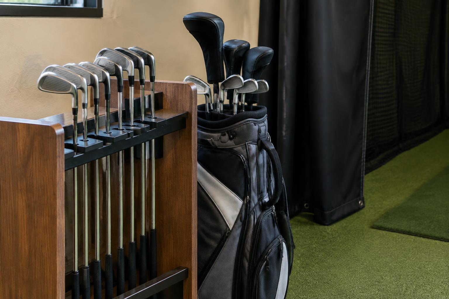 Concept rendering of golf clubs beside a simulator bay